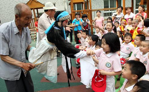 5月25日，民间艺人在西安唐都医院幼儿园为小朋友表演皮影。